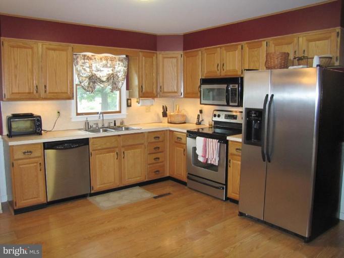 13046 Independence Road Clear Spring, MD 21722 - Photo 5 of 26 a kitchen with stainless steel appliances granite countertop a stove a sink dishwasher a refrigerator and cabinets with wooden floor