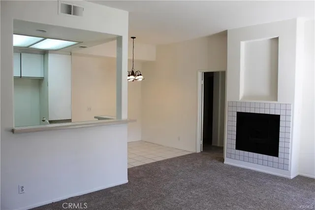 a view of an empty room with a fireplace and a window