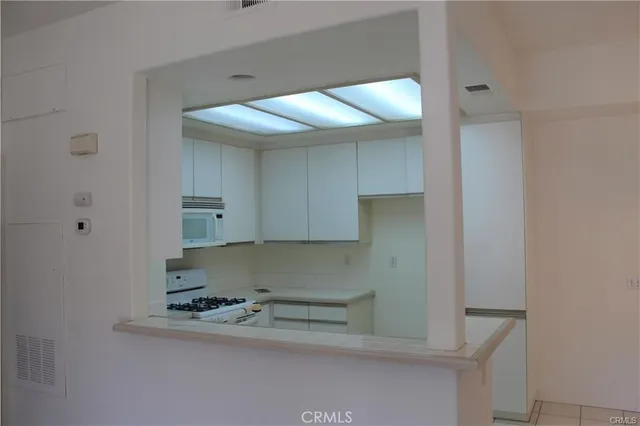 a kitchen with white cabinets and appliances