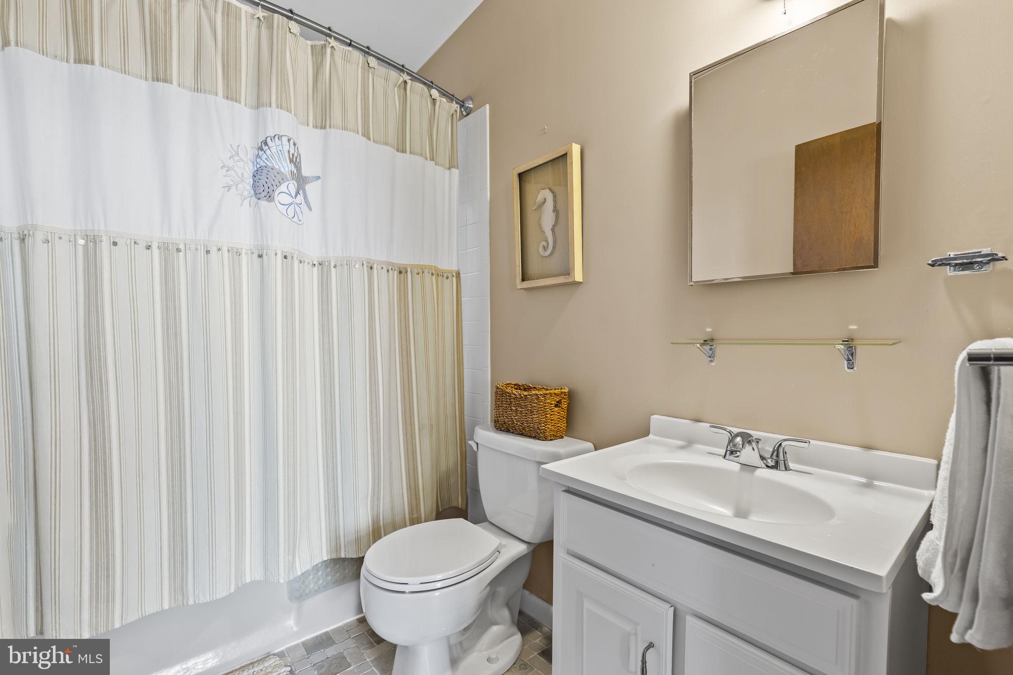 1928 Elm Road Port Republic, MD 20676 - Photo 20 of 48 a bathroom with a sink a toilet and shower curtain