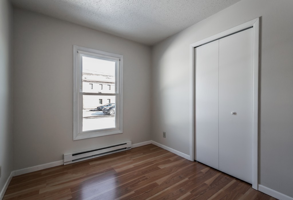 16 Prentice Street Springfield, MA 01104 - Photo 12 of 17 an empty room with wooden floor and windows