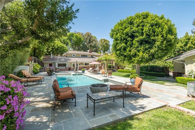 a view of a backyard with sitting area and garden