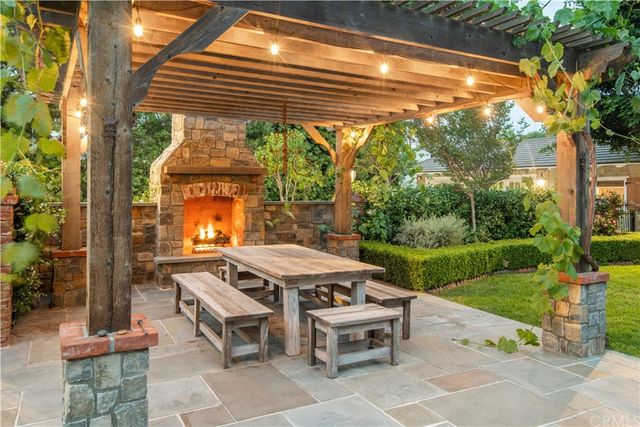 a patio with a table and chairs and potted plants