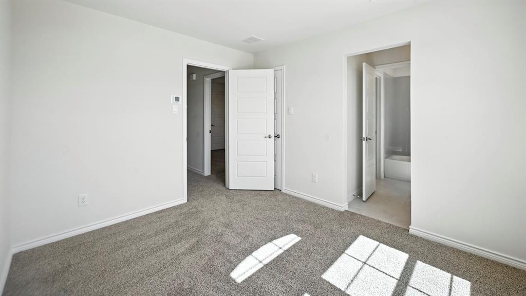 1301 Rusted Rail Drive Princeton, TX 75407 - Photo 18 of 38 Unfurnished bedroom with light colored carpet and ensuite bathroom