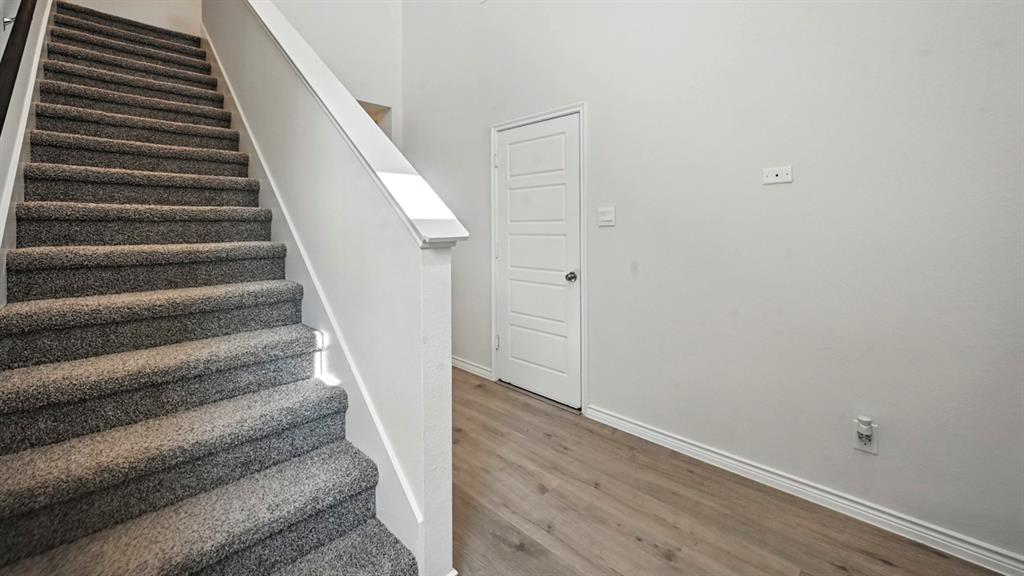 1301 Rusted Rail Drive Princeton, TX 75407 - Photo 37 of 38 Stairway featuring baseboards and wood finished floors