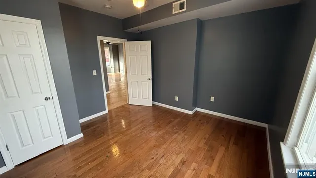 an empty room with wooden floor and closet