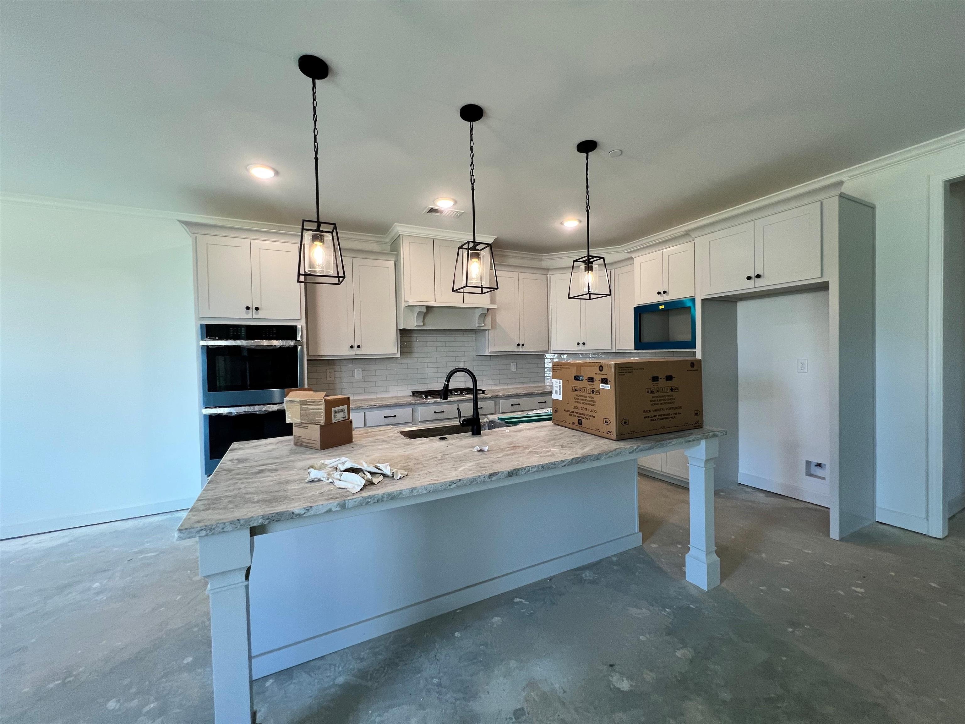 240 Drake Drive Collierville, TN 38017 - Photo 4 of 10 a large kitchen with stainless steel appliances kitchen island granite countertop a stove a sink a refrigerator and a microwave