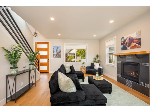 a living room with furniture a fireplace and a large window