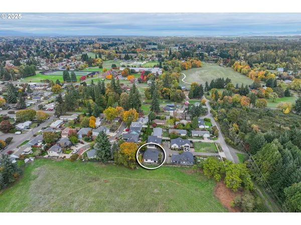an aerial view of a house with a garden and lake view
