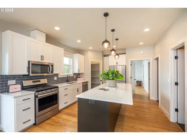 a kitchen with a refrigerator and a stove top oven