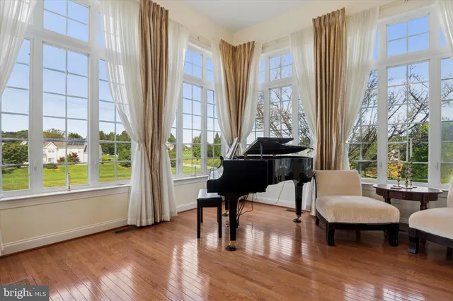 a living room with furniture kitchen view and a wooden floor