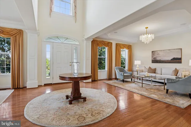 a living room with furniture two window and wooden floor