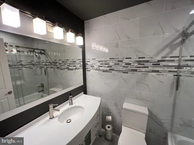 a bathroom with a sink mirror toilet and shower