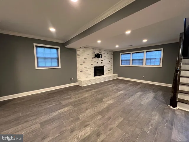 an empty room with wooden floor and window