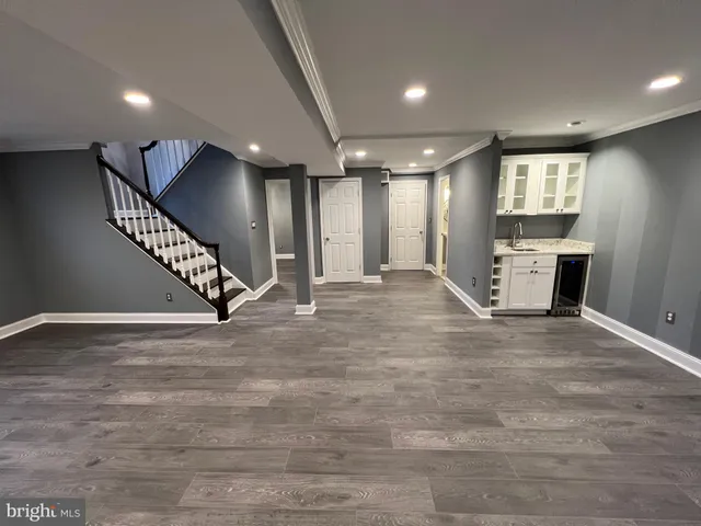 a view of an empty room with wooden floor and staircase
