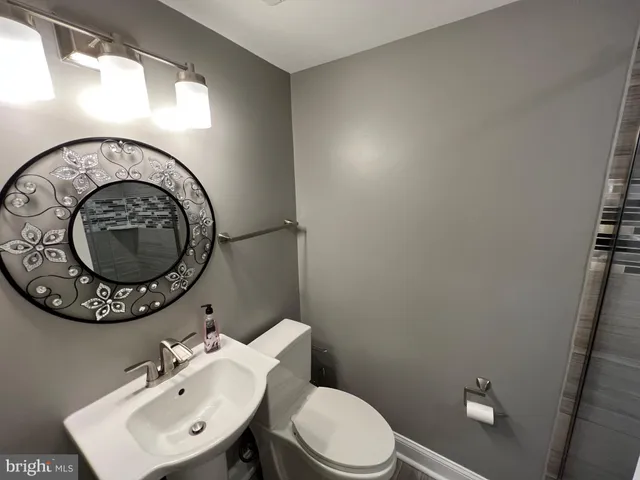 a bathroom with a toilet a sink and mirror