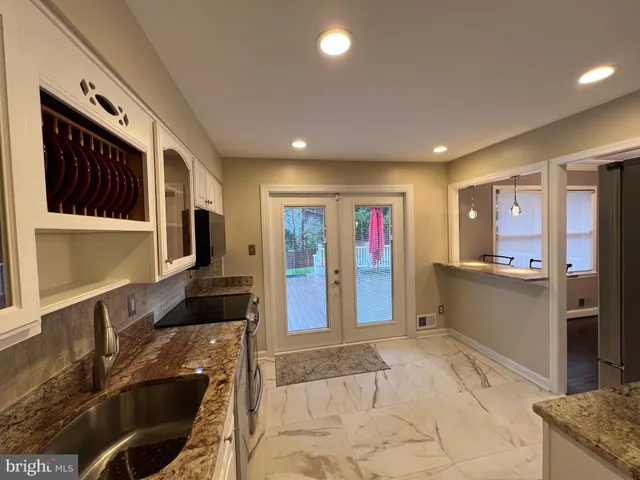 a view of entryway with kitchen island dining table and chairs