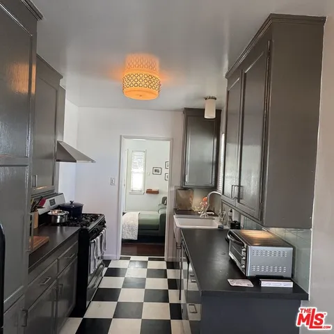 a kitchen with stainless steel appliances granite countertop a sink a stove and a refrigerator