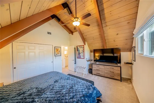 a bed room with a bed and a ceiling fan