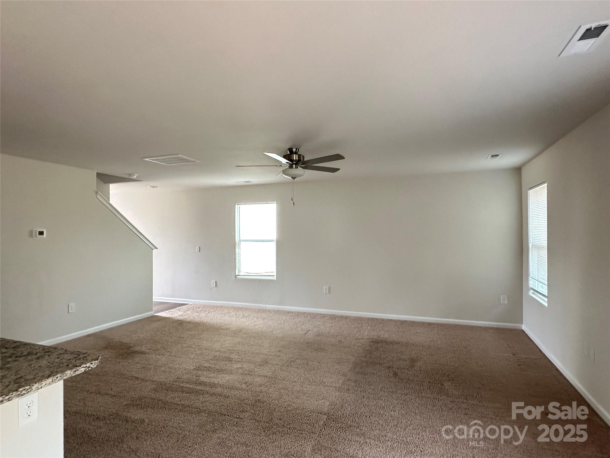 1345 Nia Road Charlotte, NC 28215 - Photo 3 of 19 an empty room with windows and ceiling fan
