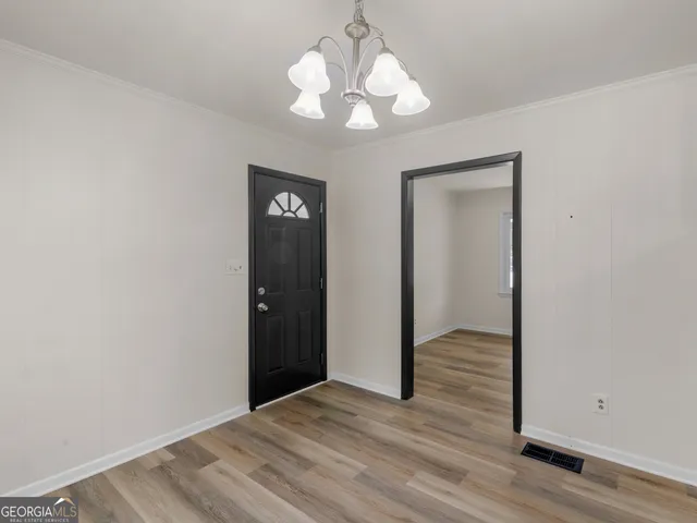 a view of an empty room with wooden floor