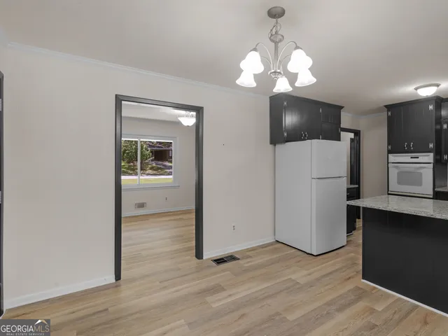 a view of a kitchen with a sink a refrigerator and wooden floor