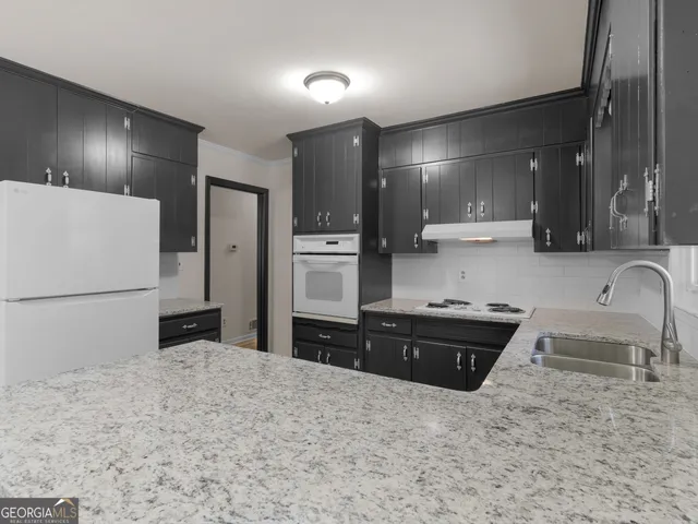 a kitchen with granite countertop a refrigerator and a sink
