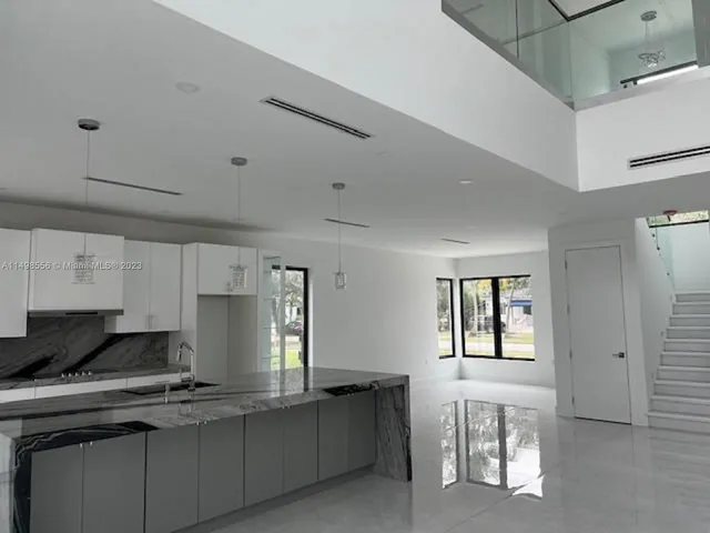 a kitchen with cabinets appliances a sink and a window