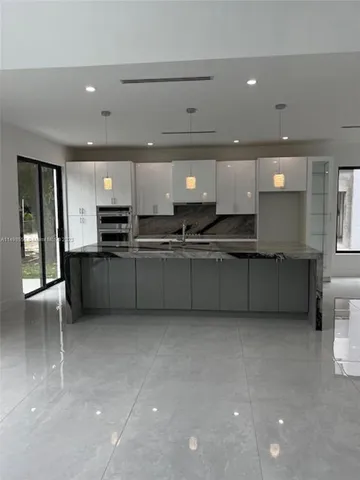 a large kitchen with stainless steel appliances a sink and a cabinets