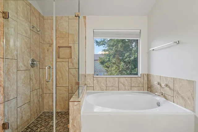 a bathroom with a bathtub and shower