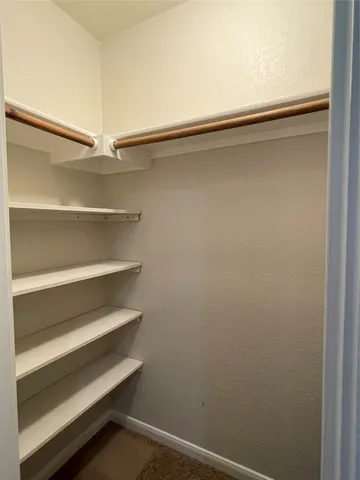 a view of walk in closet with empty racks