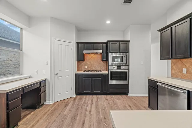 a kitchen with stainless steel appliances granite countertop a stove and a refrigerator