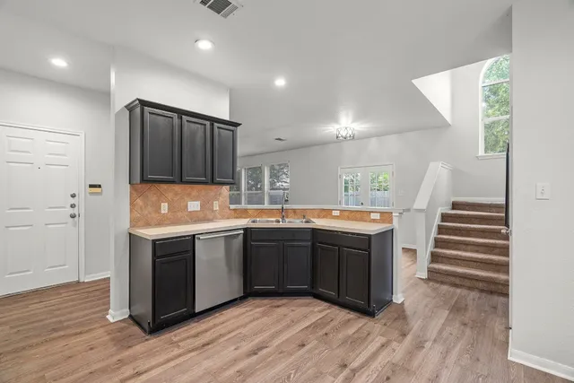 a large kitchen with wooden cabinets and stainless steel appliances