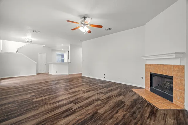 a view of empty room with fan and fireplace