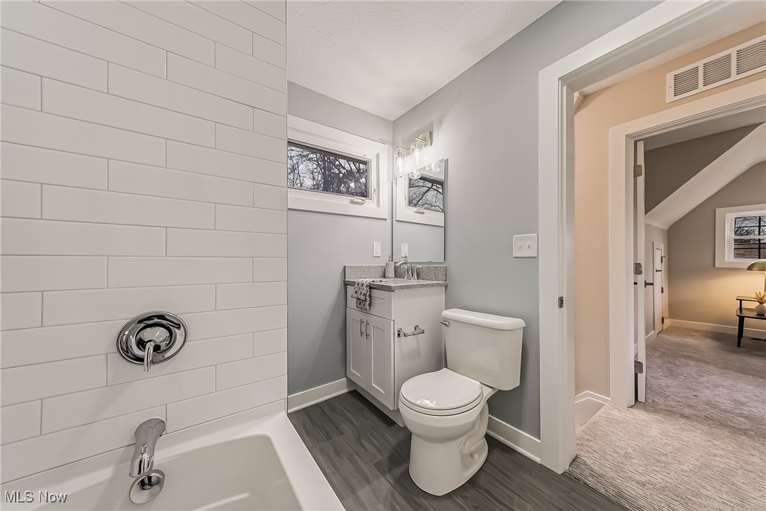 1240 Dorsh Road Cleveland, OH 44121 - Photo 21 of 36 Second floor bathroom featuring toilet, vanity, ceramic tile floors, and washtub / shower combination