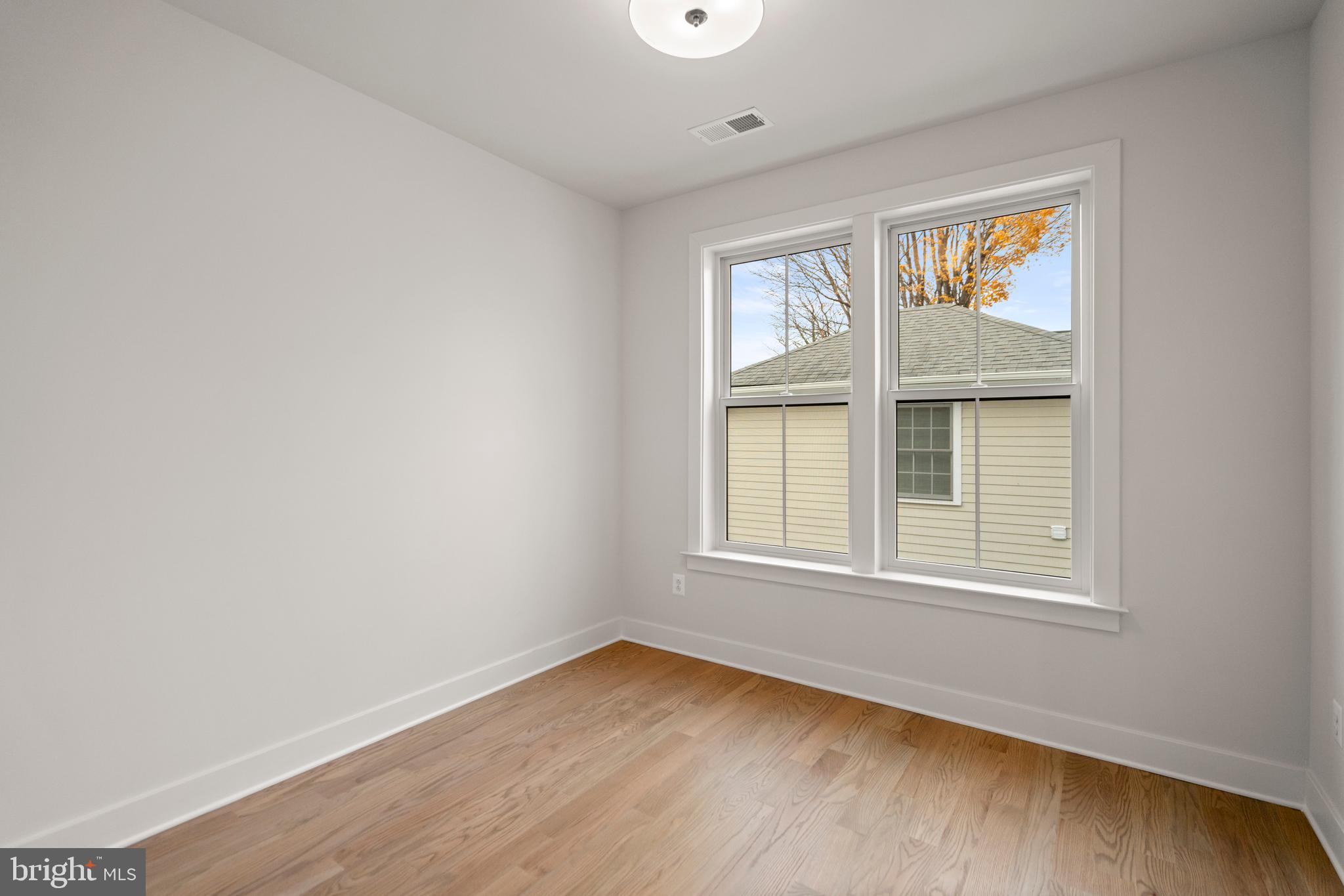 8506 Hempstead Avenue Bethesda, MD 20817 - Photo 32 of 57 an empty room with wooden floor and windows