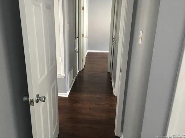 a view of a hallway with a wooden floor