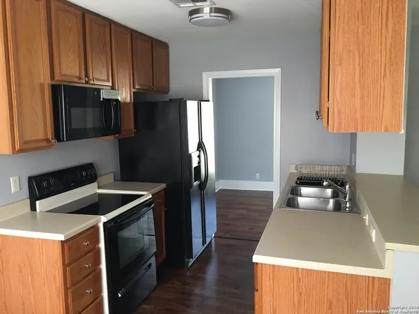 a kitchen with granite countertop a refrigerator and a sink