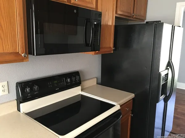 a kitchen with a refrigerator and a stove top oven