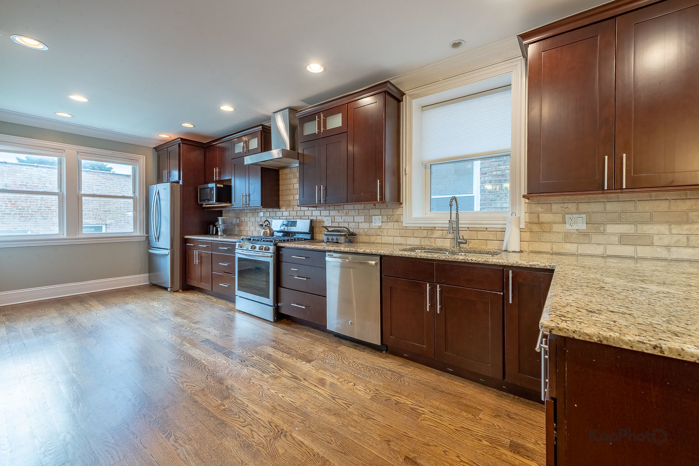 3639 North Troy Street, Unit 2 Chicago, IL 60618 - Photo 9 of 30 a kitchen with stainless steel appliances granite countertop a sink a stove a refrigerator cabinets and a large window