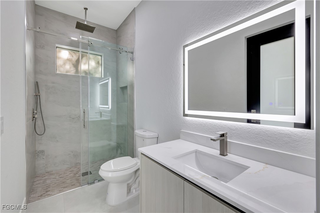 3366 72nd Avenue Northeast Naples, FL 34120 - Photo 28 of 49 a bathroom with a granite countertop sink toilet and shower