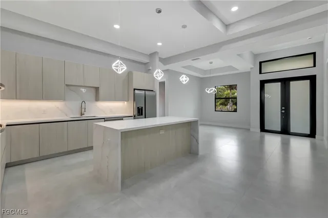 a kitchen with stainless steel appliances granite countertop a refrigerator a sink dishwasher and a stove with wooden floors