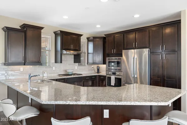 a kitchen with stainless steel appliances granite countertop a refrigerator stove and sink