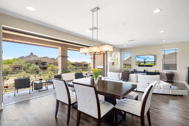 a living room with stainless steel appliances granite countertop furniture and a wooden floor