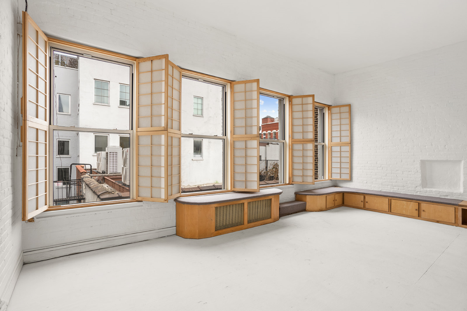 169 Spring Street, Unit 5W Manhattan, NY 10012 - Photo 16 of 20 a view of an empty room with a fireplace and a large window