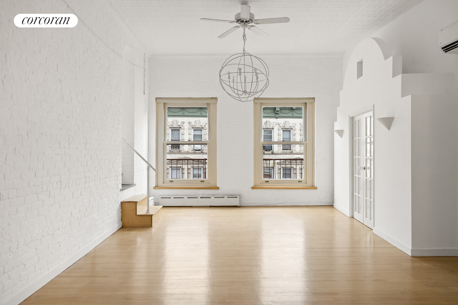 169 Spring Street, Unit 5W Manhattan, NY 10012 - Photo 3 of 20 a view of an empty room with wooden floor and a window