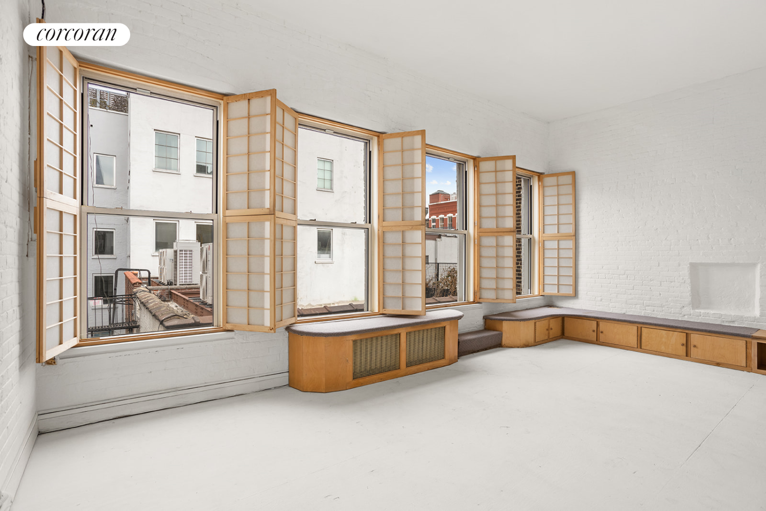 169 Spring Street, Unit 5W Manhattan, NY 10012 - Photo 7 of 20 a view of an empty room with a fireplace and a large window