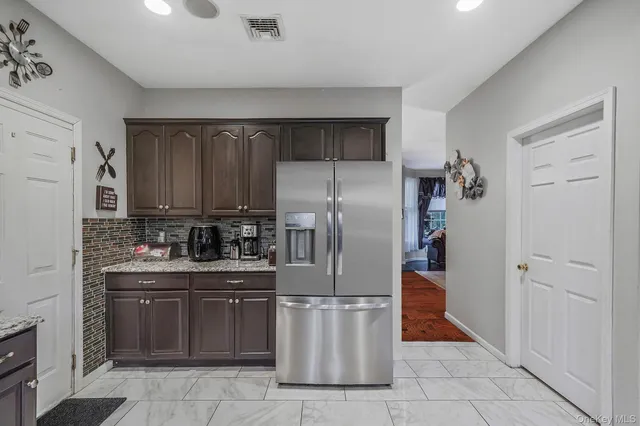 a kitchen with stainless steel appliances granite countertop a refrigerator and a stove