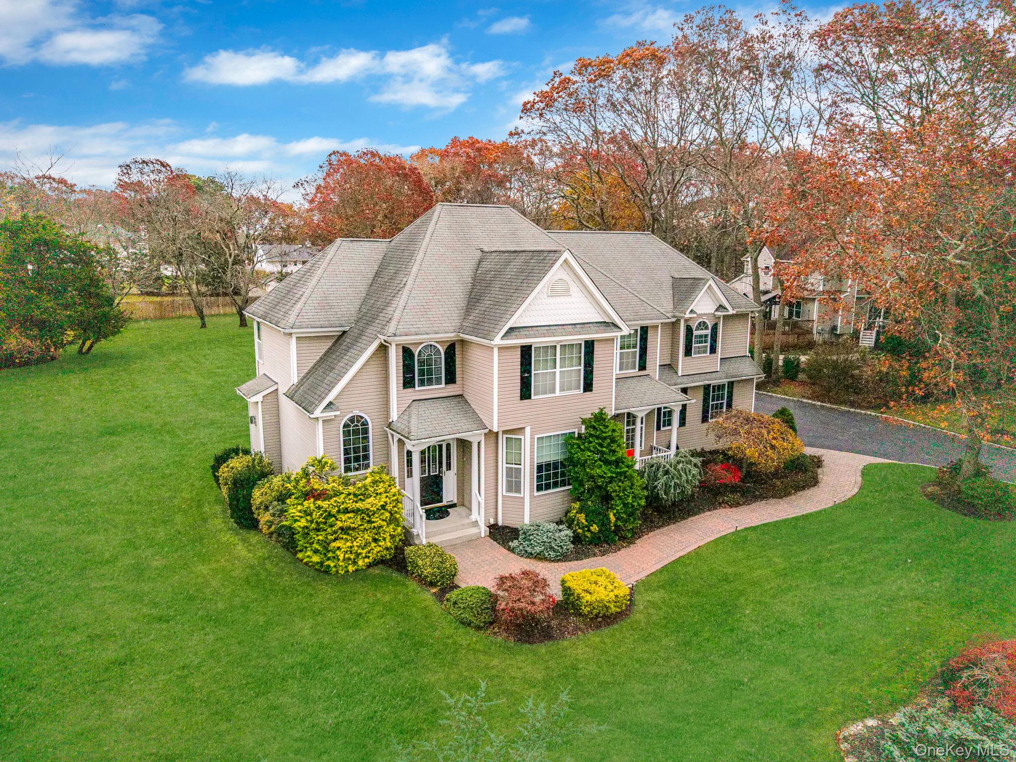 9 Paddock Lane Medford, NY 11763 - Photo 38 of 49 View of front facade featuring a front yard, roof with shingles, and view of wooded area