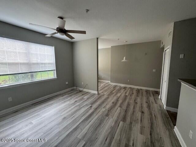 5692 Star Rush Drive, Unit 106 Melbourne, FL 32940 - Photo 8 of 16 a view of empty room with wooden floor and fan